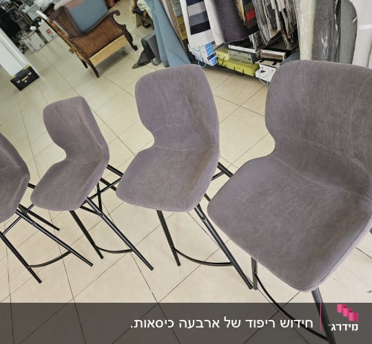 ארבעה כיסאות בר מרופדים מחדש בבד אפור בבית מלאכה לרפדות